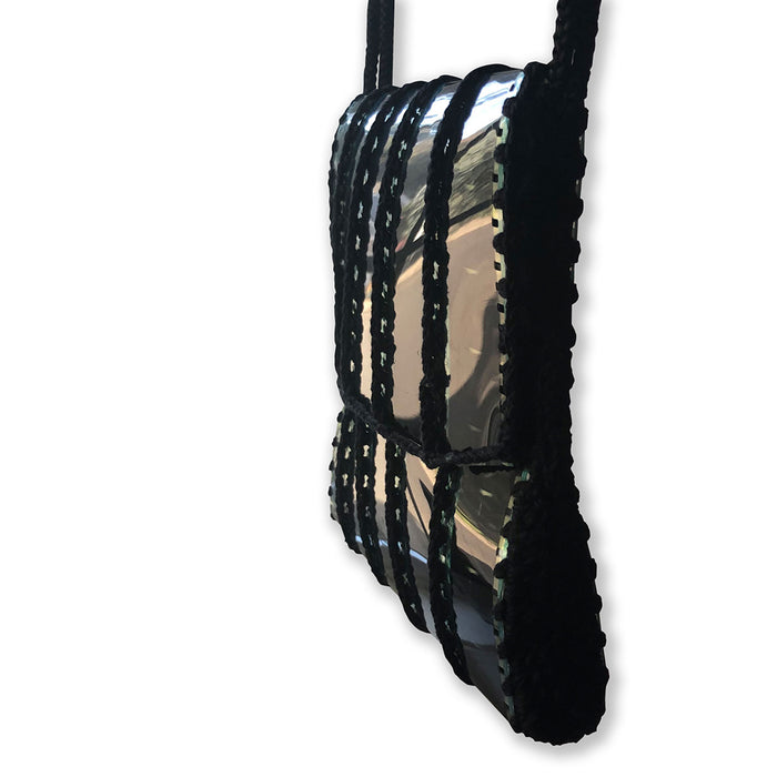 Black woven bag with a reflective surface on a white background