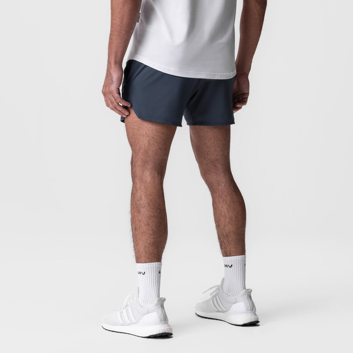 AeroSilver 5" Linerless Short in navy, worn by model with white socks and sneakers, back view