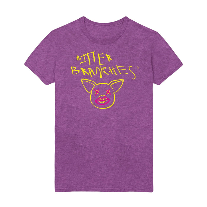 Purple tshirt with scratchy style yellow text reading Bitter Branches on the top part of the shirt with a yellow outline of a pig face below. Pink Xs are drawn over the pig's eyes and pink lips are drawn over the pig's snout.
