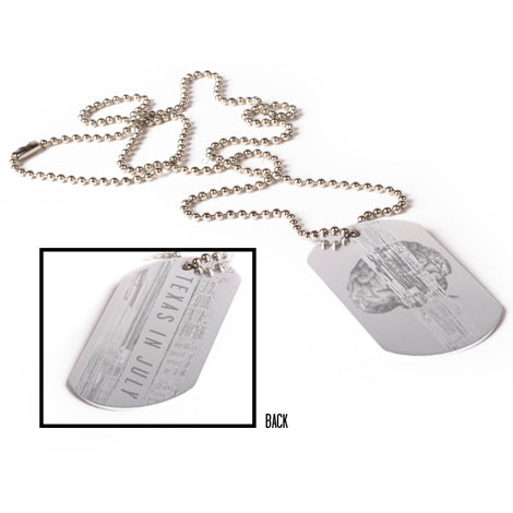 A Texas In July silver ball chain necklace with a Brain Silver Dog Tag, featuring faintly engraved text and a mushroom cloud illustration. Inset displays a close-up of the tag’s engraved details.