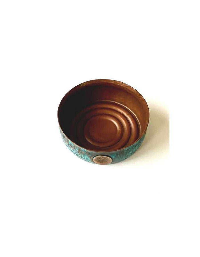 Interior view of copper lather bowl with smooth copper interior, textured aquamarine exterior, and copper emblem detail, ergonomic design