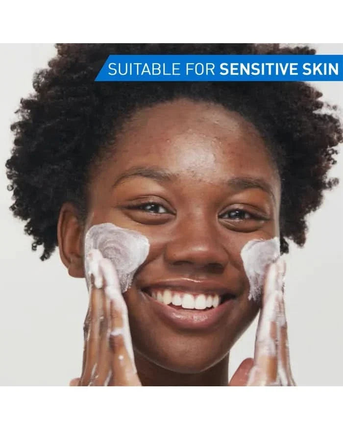 Person applying CeraVe Blemish Clay To Foam Cleanser on cheeks, foamy lather visible, light grey background, text reads "Suitable for Sensitive Skin"