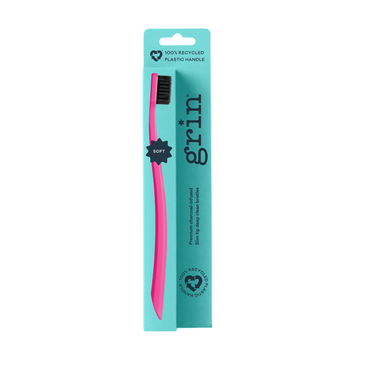 Grin 100% Recycled Toothbrush Soft Fuchsia with dark bristles in teal packaging on white background