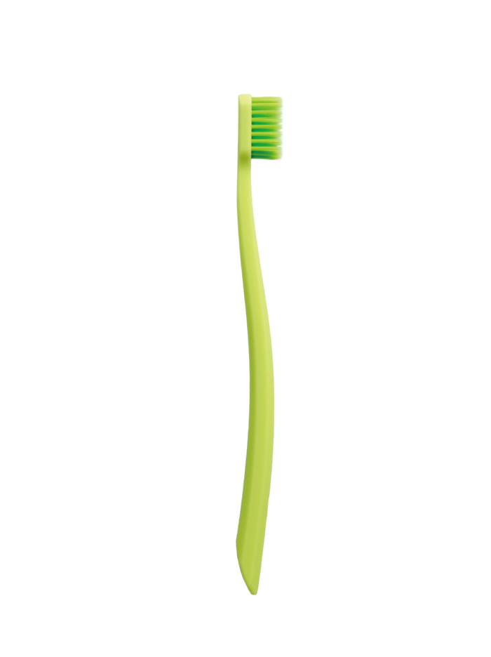 Grin Pro Ultimate Gentle Care Toothbrush in green with ultra soft bristles, curved handle, on white background.