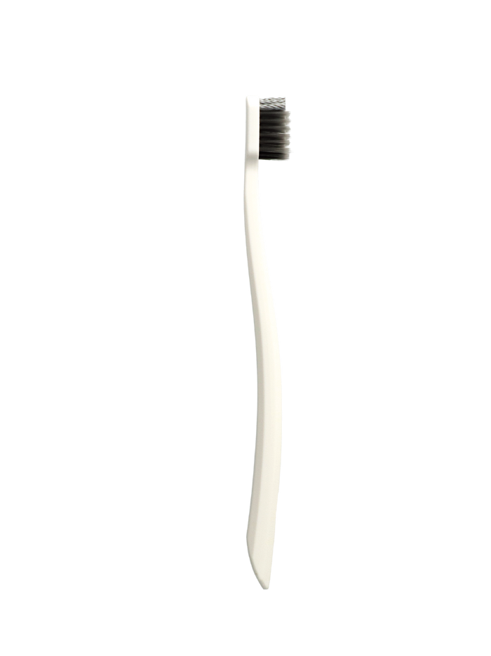 Grin Pro Ultimate Whitening Toothbrush with white handle and dark soft bristles on a white background.