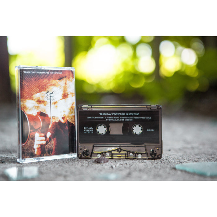 The cassette is depicted on cement amidst broken glass.