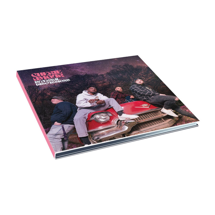 Square CD with an image of band members sitting on top of a red car. In the background are trees and the night sky, which is tinted pink along with the rest of the cover. In the top left corner there is pink text that says CHERIE AMOUR. Below that is white text that says INTERNAL DISCUSSIONS.