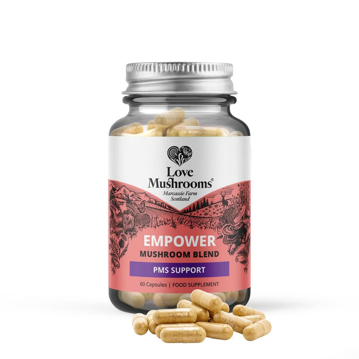 Love Mushrooms Empower PMS GO 60 Capsules glass jar with silver lid on white background, capsules scattered in front.
