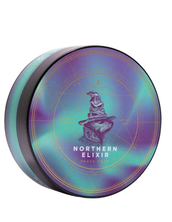 Holographic round tin of Noble Otter Northern Elixir Shaving Soap with a mystical dog illustration and gold geometric accents