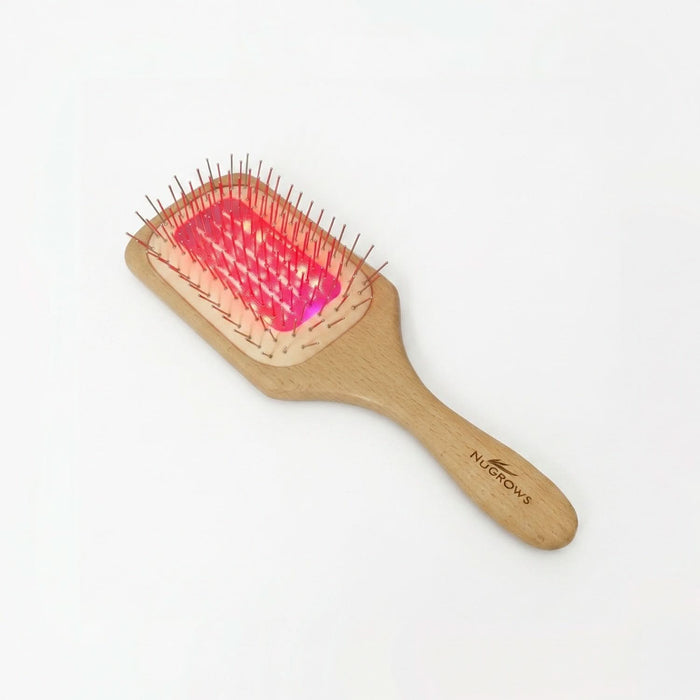 NuGROWS VivaBrush Pro wooden paddle brush with metal pins and glowing pink laser pad, "NUGROWS" engraved on handle, white background.