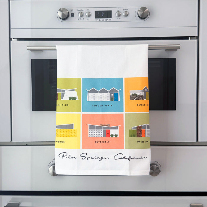 Colorful towel with midcentury Palm Springs architectural designs hanging on a kitchen oven.