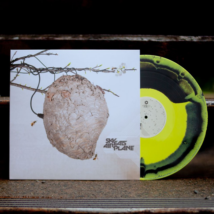 Black and yellow mix vinyl. Vinyl Jacket has picture of bees nest hanging from tree branch. 2 bees flying toward the nest. Bottom right corner has "SKY EATS AIRPLANE" printed.