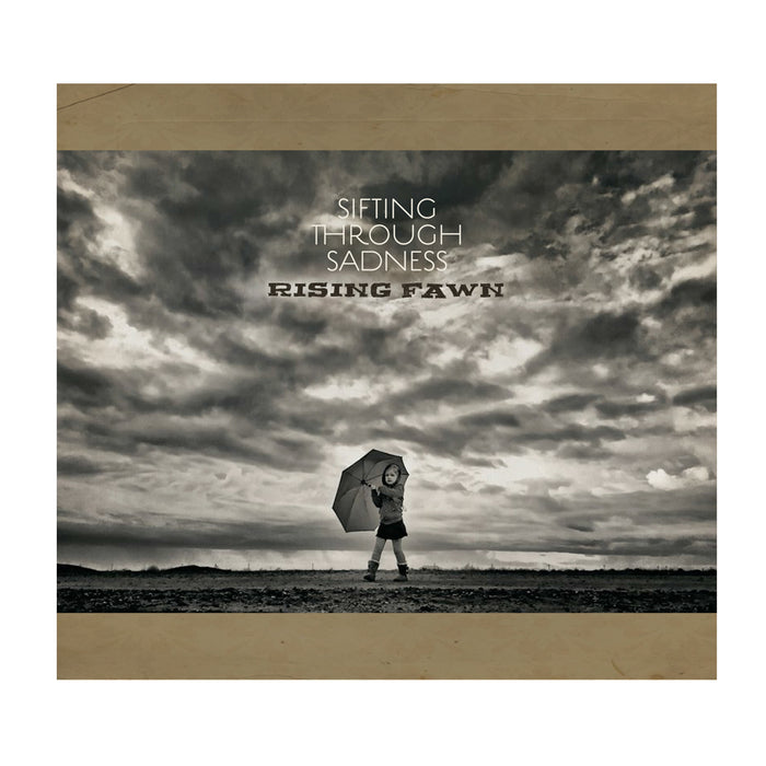 A child with an umbrella stands solo under a dramatic, cloudy sky. The text reads "Sifting Through Sadness" above and "Rising Fawn" below—striking black and white imagery, perfect as CD cover art or tracklist inspiration for Rising Fawn.