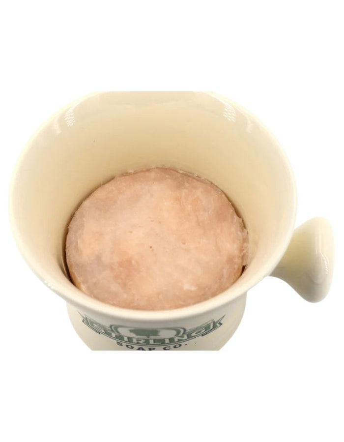 Interior of cream ceramic shaving mug with soap puck at the bottom, featuring a sturdy handle for comfortable grip during grooming